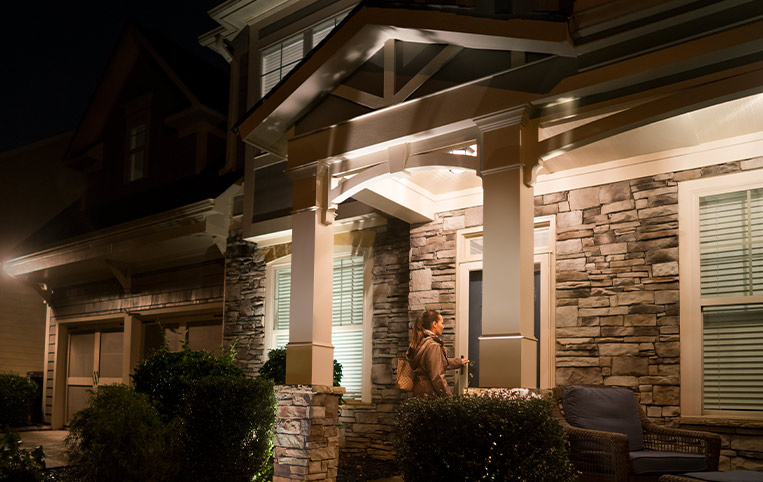 Man entering a well-lit home at night.